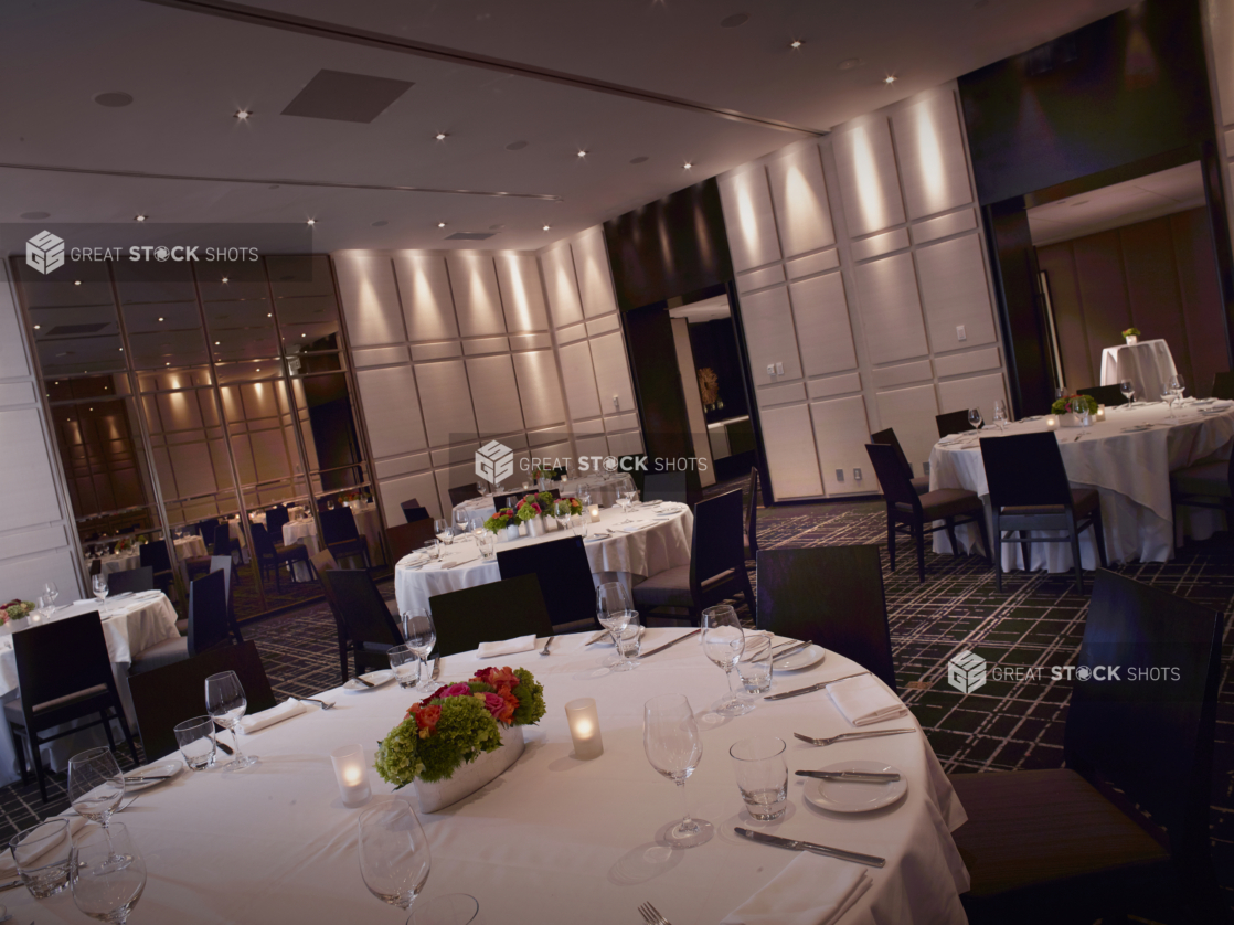 Classy, High-End Restaurant Interior with Large Round Formal Table Settings and Moody Lighting for a Large Formal Reception Setting