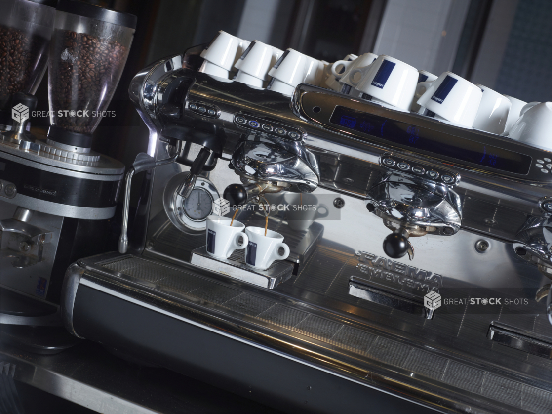 Commercial Espresso Coffee Machine Pouring Espresso into Two Ceramic Cups in a Restaurant Coffee Counter Setting