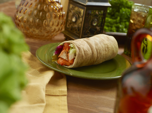 BBQ Chicken Kebab Pita Wrap with Pickled Veggies and Fresh Vegetables on a Round Ceramic Dish on a Wooden Table in an Indoor Setting