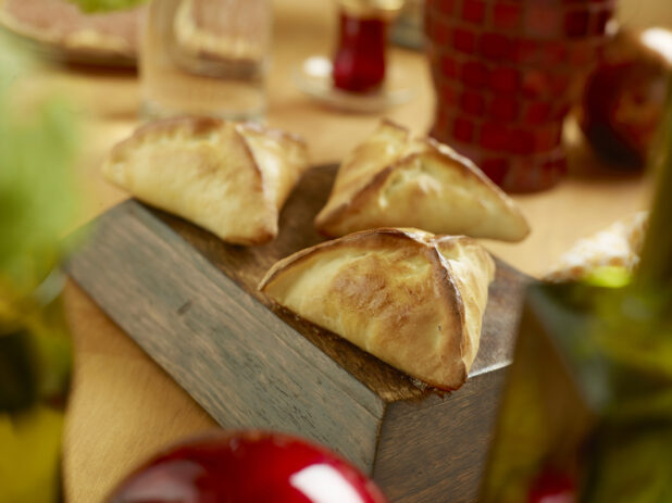 Fatayer - Middle Eastern Baked Stuffed Spinach Pies on a Wooden Table in an Indoor Setting