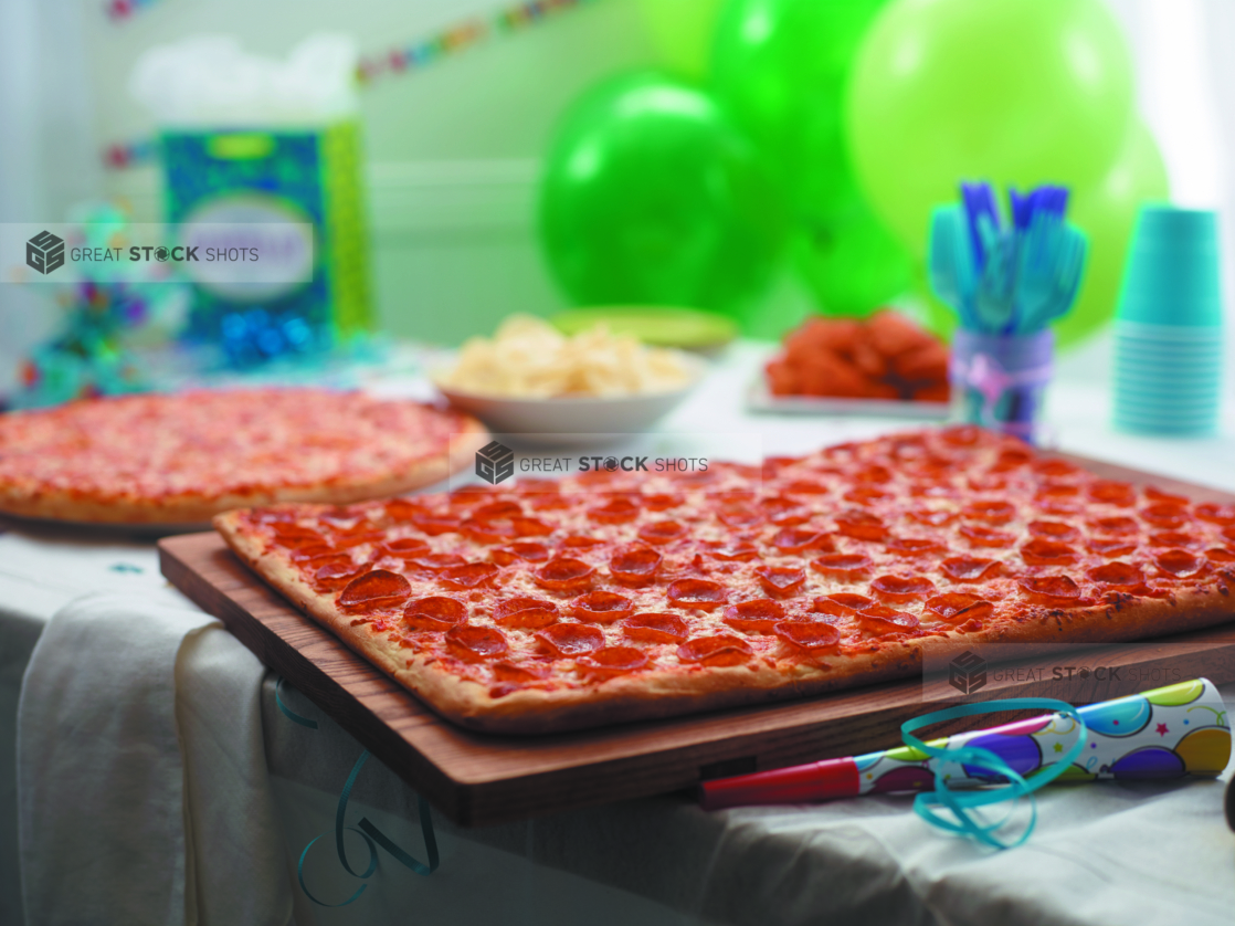 Birthday Pizza Party with Party-sized Pepperoni Pizza, Cheese Pizza, BBQ Chicken Wings, Potato Chips and Party Decorations in a Bright Indoor Family Room