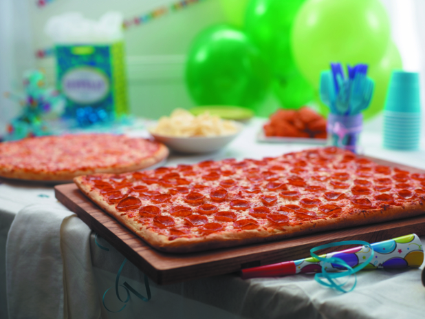 Birthday Pizza Party with Party-sized Pepperoni Pizza, Cheese Pizza, BBQ Chicken Wings, Potato Chips and Party Decorations in a Bright Indoor Family Room