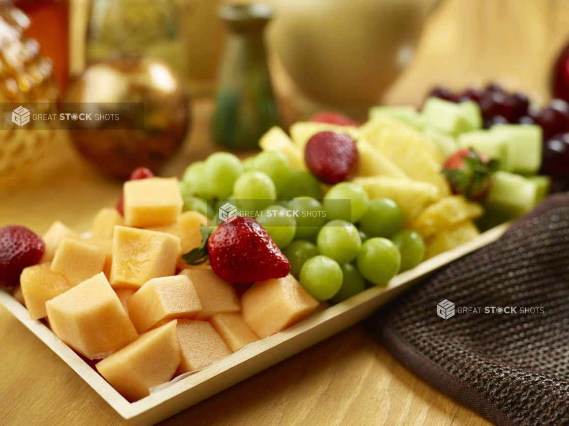 Cut fruit on a wooden catering tray