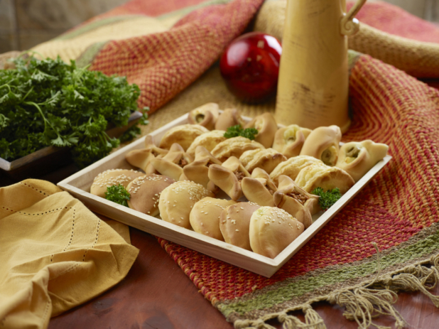 Small Middle Eastern Savoury Pie Platter (zaatar, safeeha, fatayer) in a Square Wooden Serving Tray for Catering on a Woven Placemat in an Indoor Setting
