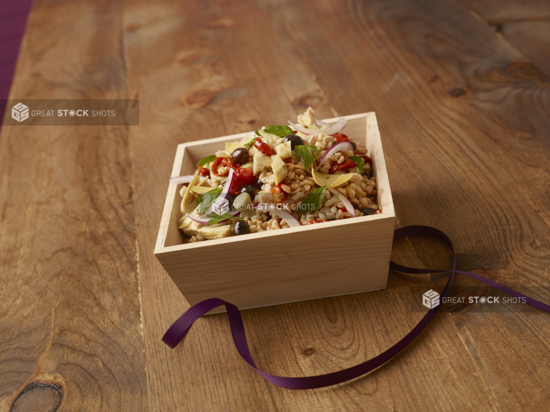 Mediterranean-style rice salad in a wooden catering box