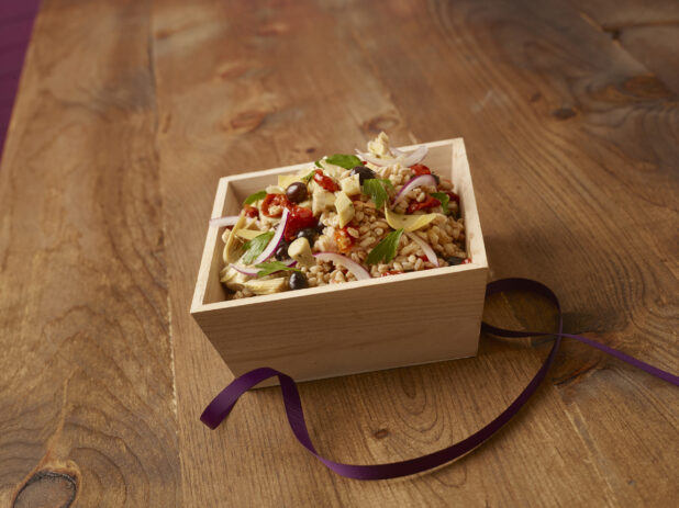 Mediterranean-style rice salad in a wooden catering box