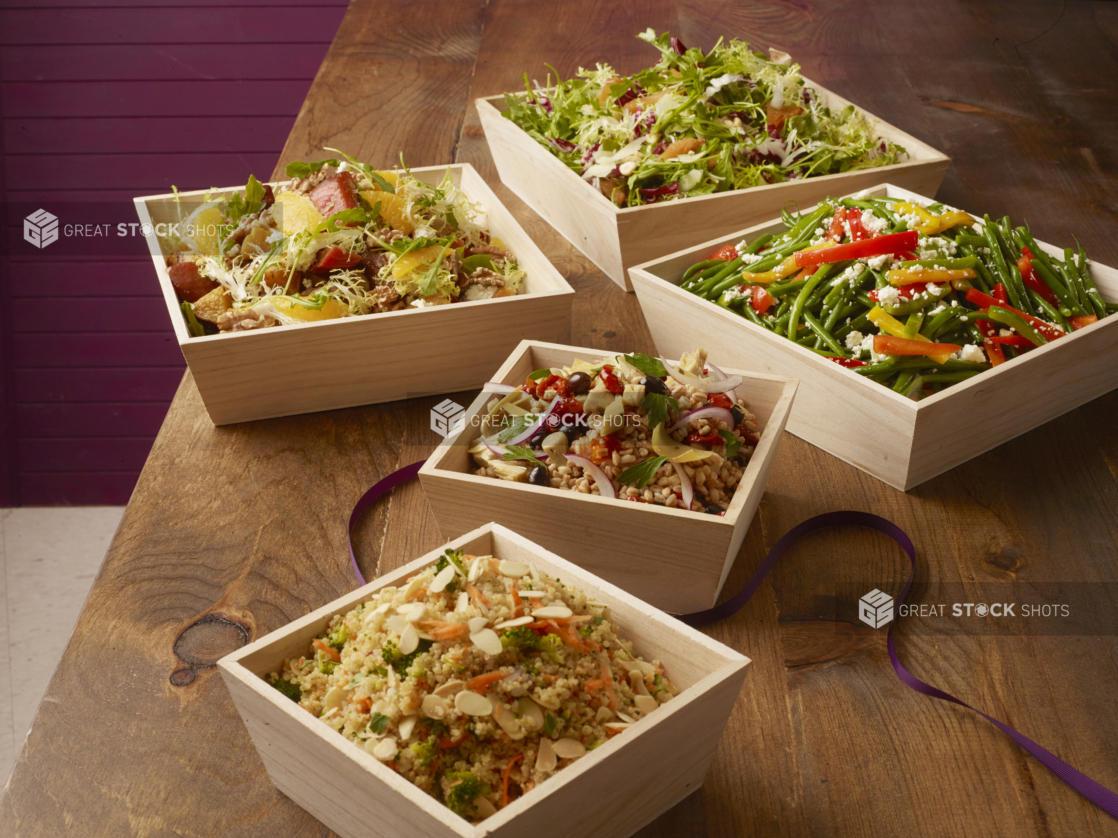 Various cold salads in wood catering boxes, wood background