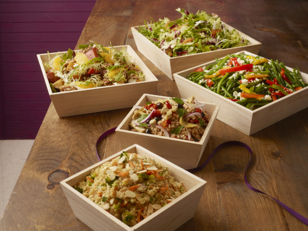 Various cold salads in wood catering boxes, wood background