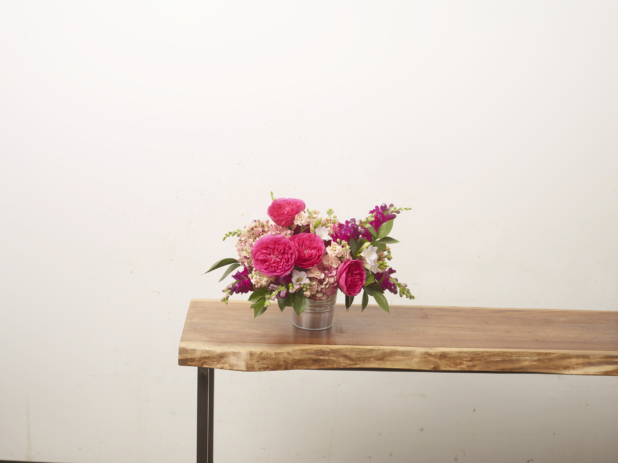A Bouquet of Pink Monochromatic Flowers in a Floral Arrangement on a Wooden Table