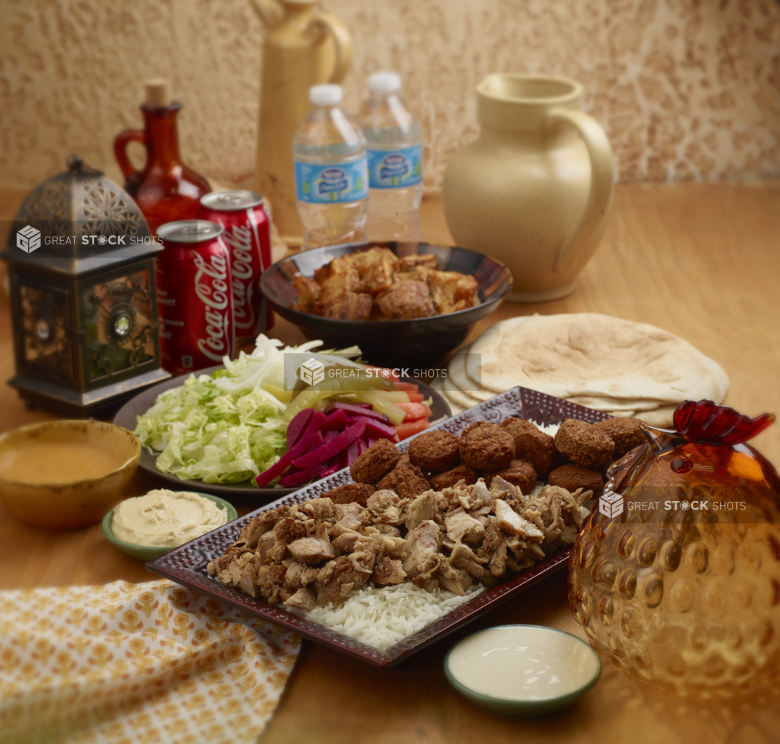 A Family Special Combo of Falafel Balls and Chicken Shawarma with Fresh and Pickled Vegetables, White Rice, Roasted Garlic Potatoes, Pita Bread and Cold Drinks