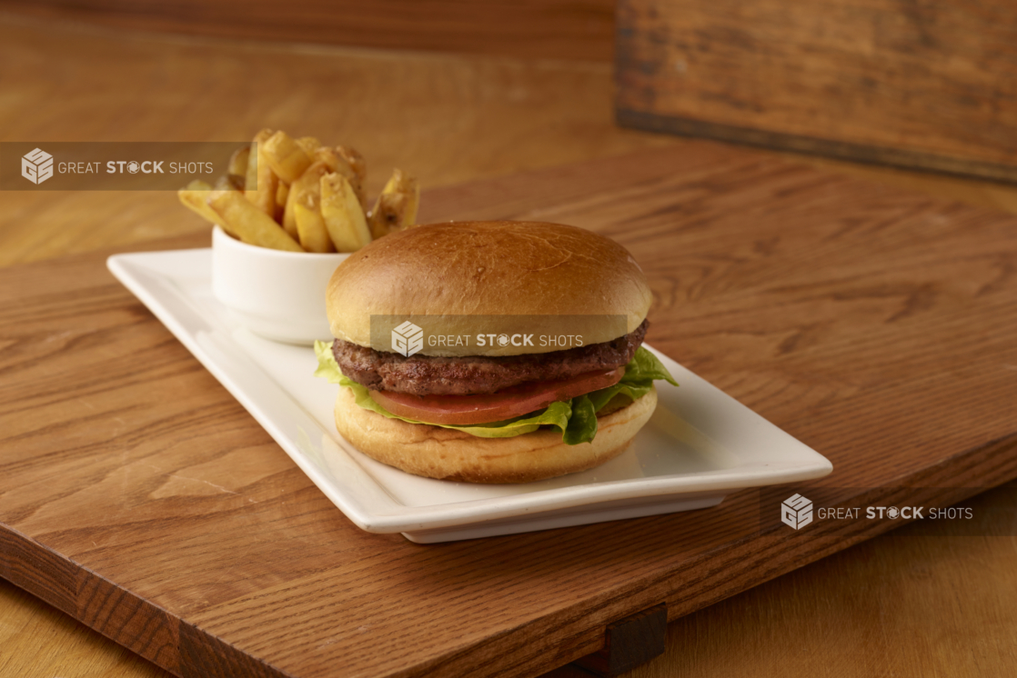 Kids Hamburger and Fries Combo Meal on a Rectangular White Ceramic Platter on a Wooden Cutting Board in an Indoor Setting