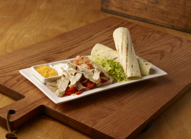 Kids Grilled Chicken Fajita Platter on a Rectangular White Ceramic Dish with Fresh and Cooked Ingredients and Toppings on a Wooden Cutting Board in an Indoor Setting
