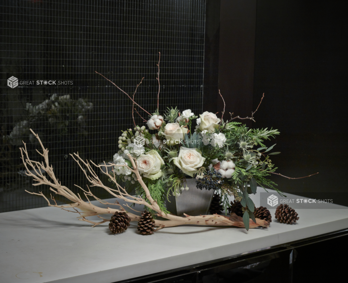 Floral Centrepiece of White Pink Roses, Cotton Flowers, White Miniature Roses, Brunia Berries, Elderberries and Assorted Greenery with a Large Dried Branch and Pine Cones