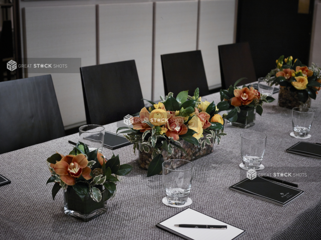 Close Up of Yellow and Orange Floral Arrangements for a Formal Business Meeting in an Indoor Setting