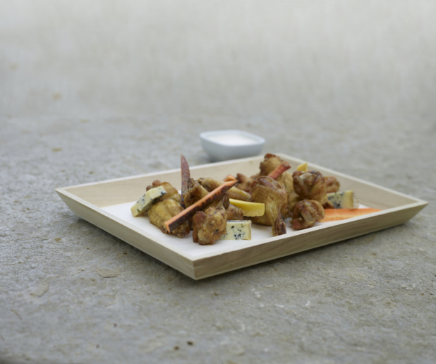 Chicken wings on a wood tray with cheeses and crudite