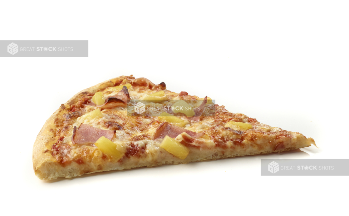 Side View of a Jumbo Hawaiian Pizza Slice with Pineapple Chunks and Sliced Ham Shot on White for Isolation