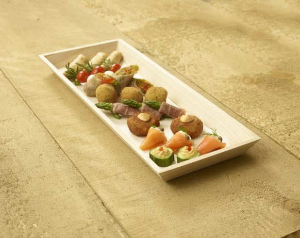 A Narrow Rectangular Wood Serving Tray with Assorted Passed Appetizers (Smoked Salmon Rolls, Croquettes, Spring Rolls, Cucumber Bites, Caprese Skewers) for Catering on an Untreated Wood Surface