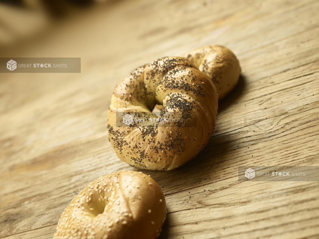 Assorted whole bagels on a wooden background