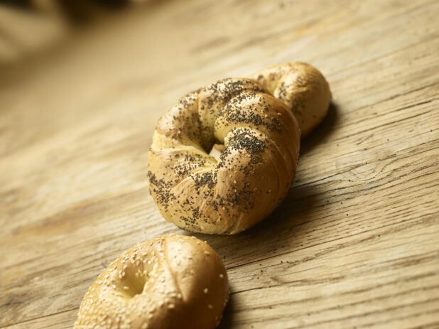 Assorted whole bagels on a wooden background