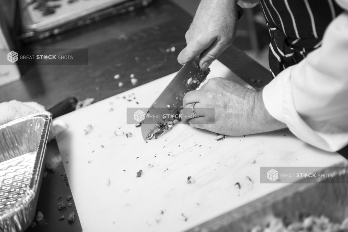 Black and white photo of chef prepping in a restaurant kitchen