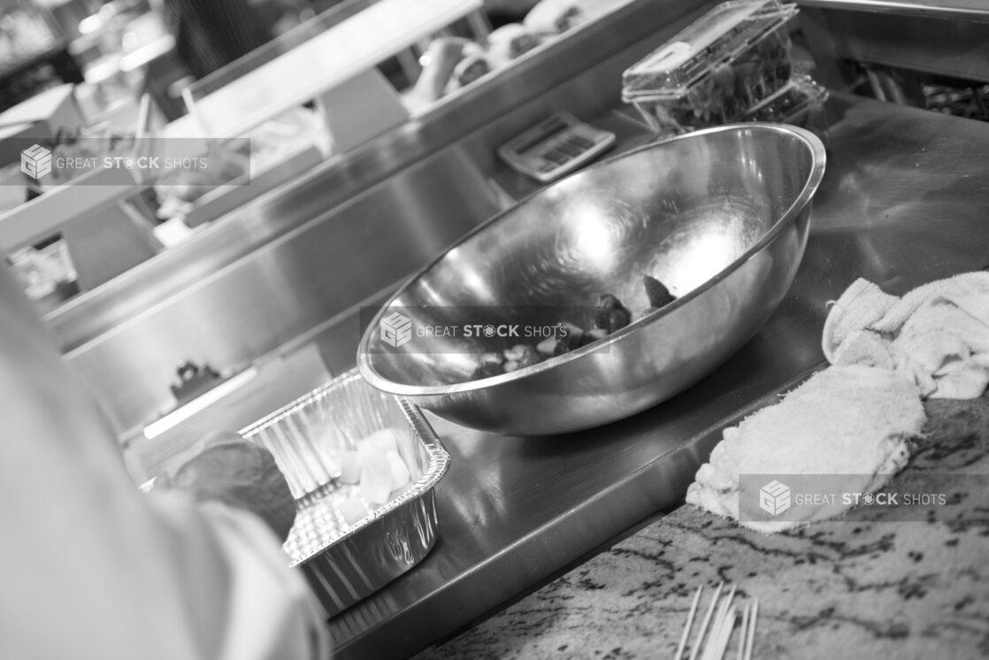 Black and white photo of chef prepping in a restaurant kitchen