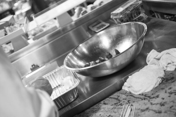 Black and white photo of chef prepping in a restaurant kitchen