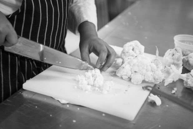 Black and white photo of chef prepping cauliflower