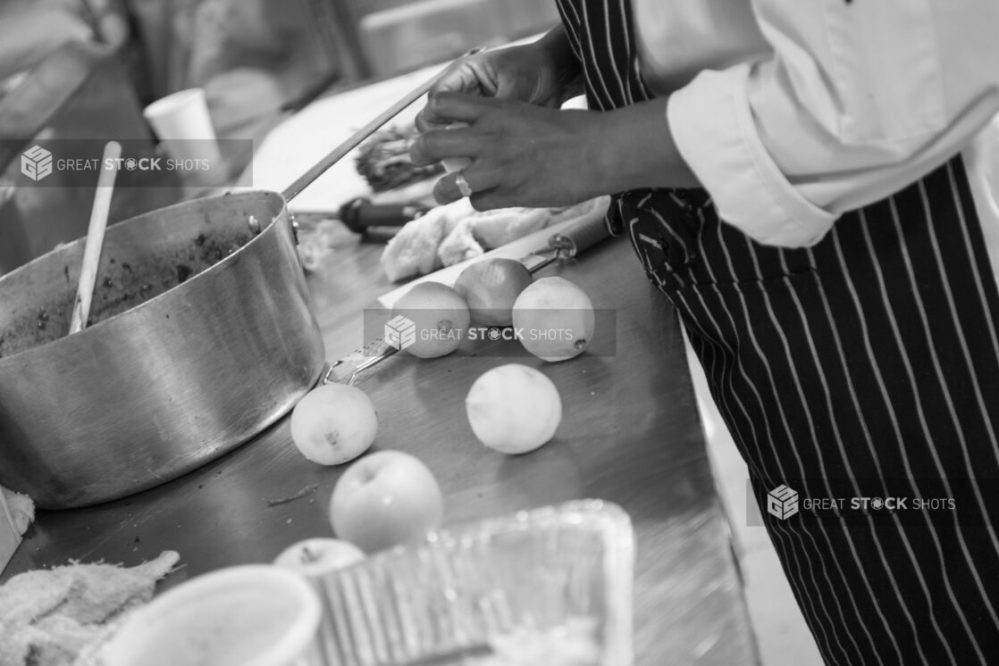 Black and white photo of a chef prepping in a kitchen