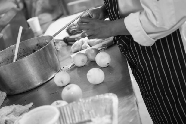 Black and white photo of a chef prepping in a kitchen