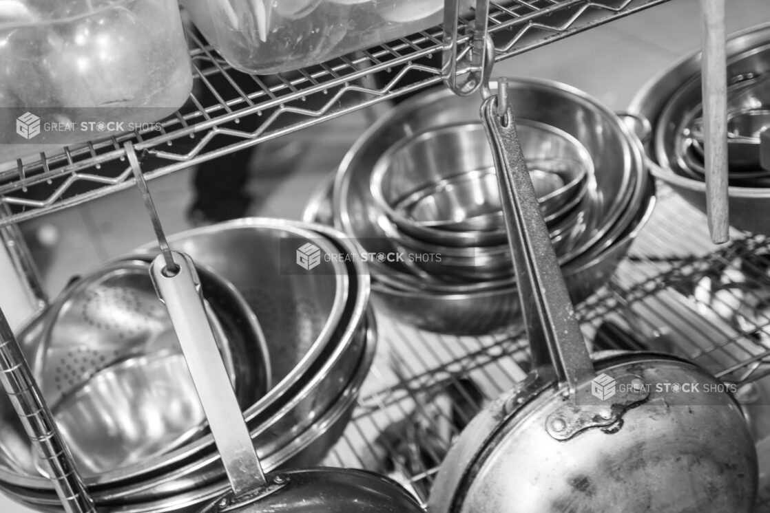 Black and white photo of kitchen equipment on a metal wire rack