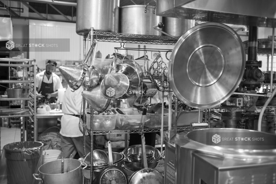 Black and white photo of a restaurant kitchen with equipment and chefs