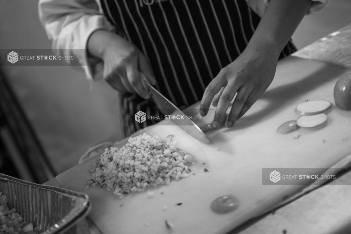 Black and white photo of a chef chopping/prepping cut apples