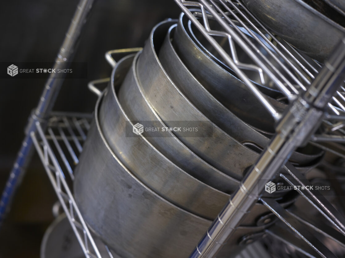 Saucepans stacked on a wire shelf on an 45 degree angle