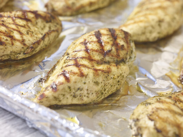 Grilled chicken breasts on a tin foil background in a close up view