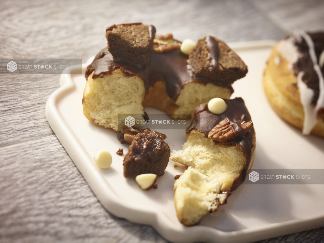 Brownie donut on a white patter on a grey wooden background, broken open