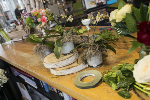 Floral designing on a wooden table, in a floral shop setting
