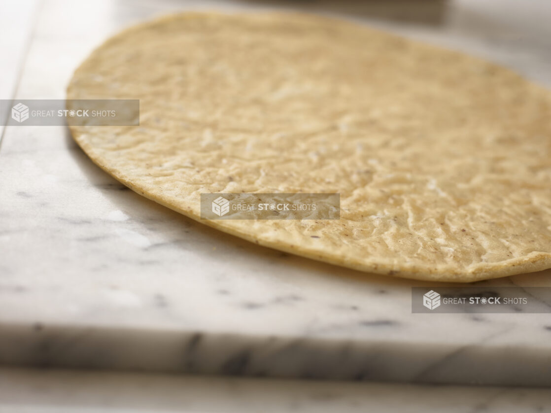 Whole flatbread in a close up view on a 45 degree angle on marble background