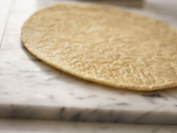 Whole flatbread in a close up view on a 45 degree angle on marble background