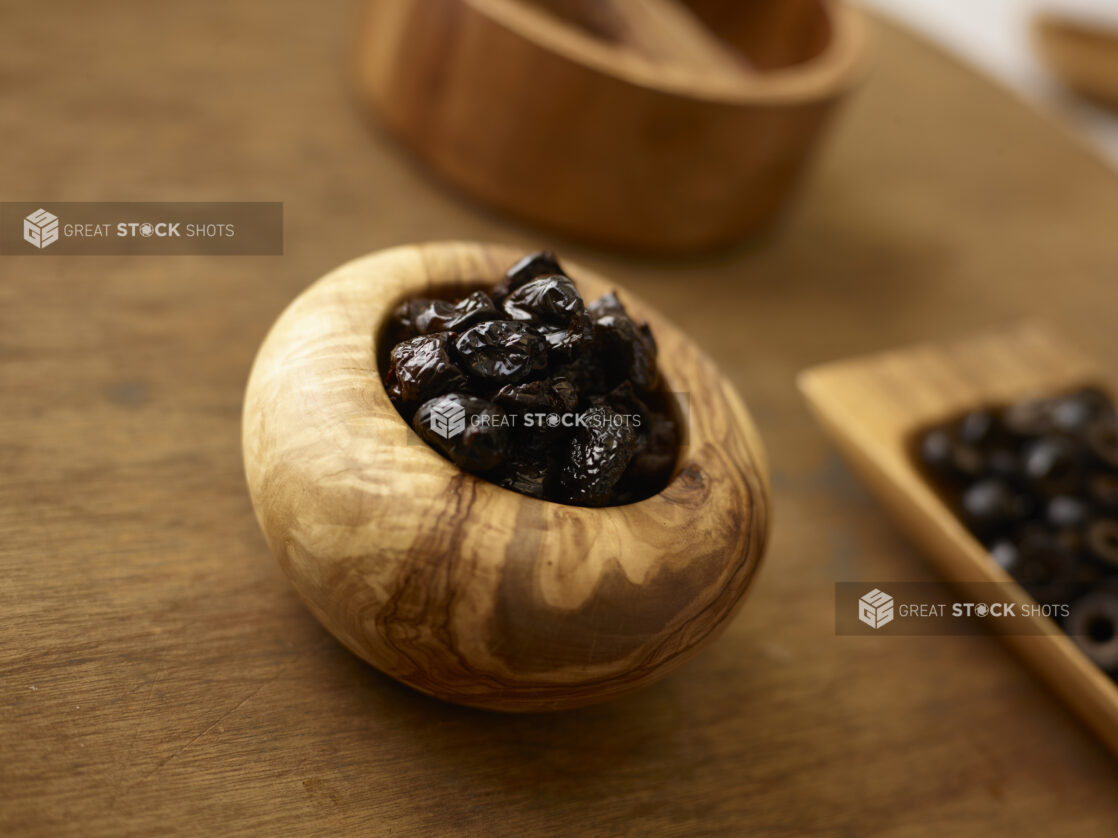 Dates in a decorative wooden bowl on a rustic wooden background