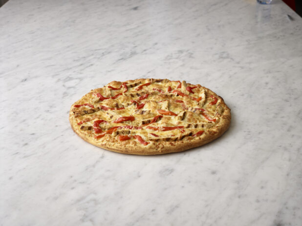 Whole 2 topping pizza with chicken and roasted red peppers on a white marble background