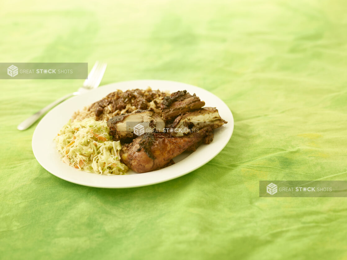 BBQ chicken dinner on white plate on a lemon/lime tablecloth