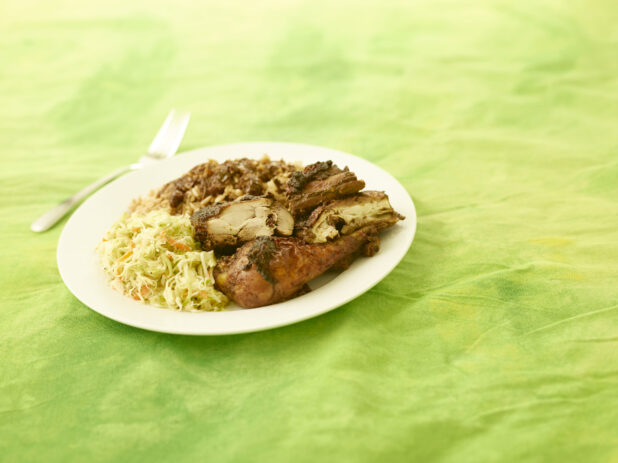 BBQ chicken dinner on white plate on a lemon/lime tablecloth