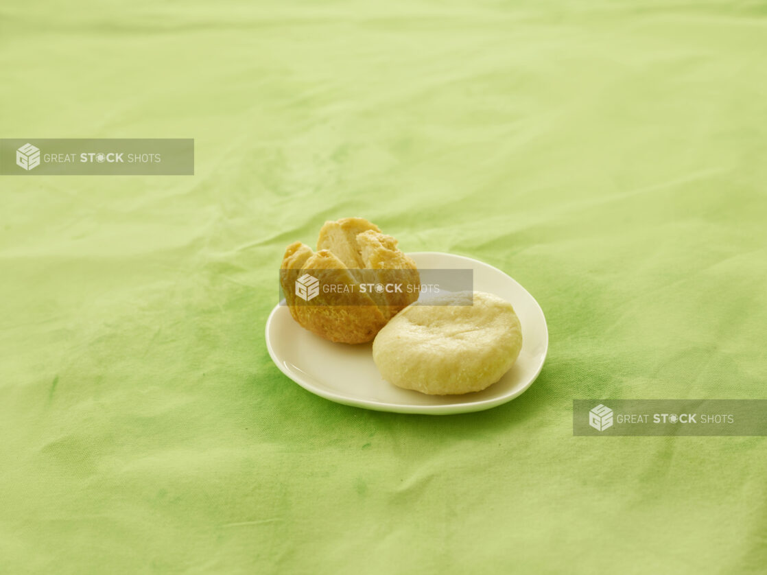 Fried and boiled dumplings on a white side plate on a lemon/lime green tablecloth