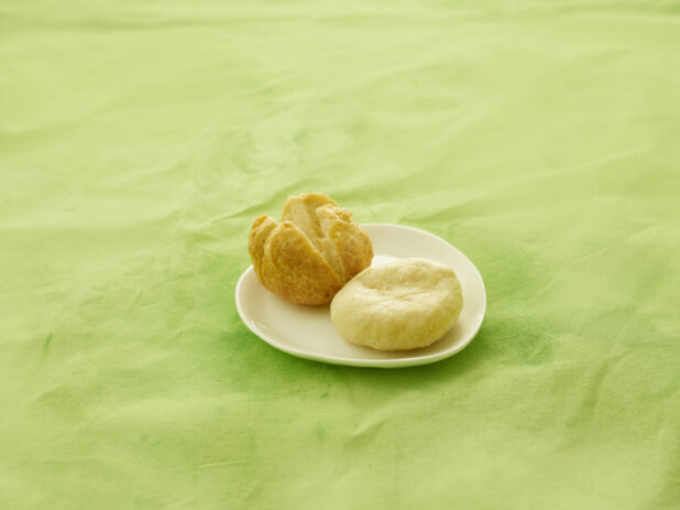 Fried and boiled dumplings on a white side plate on a lemon/lime green tablecloth