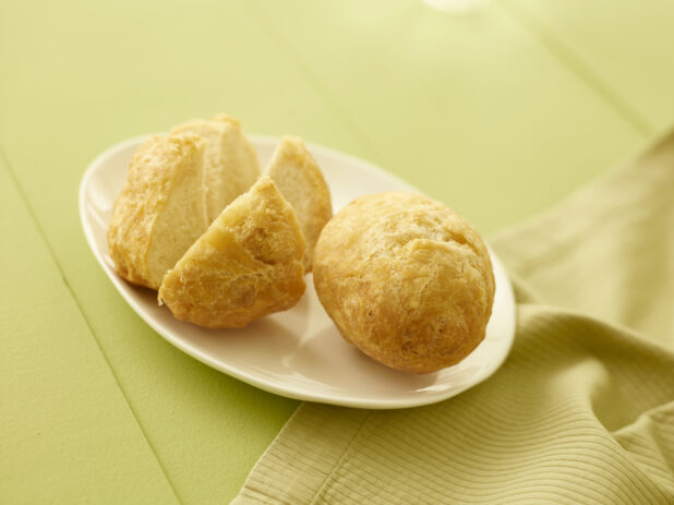 2 Caribbean fried dumplings, on a white side plate on a pale green table