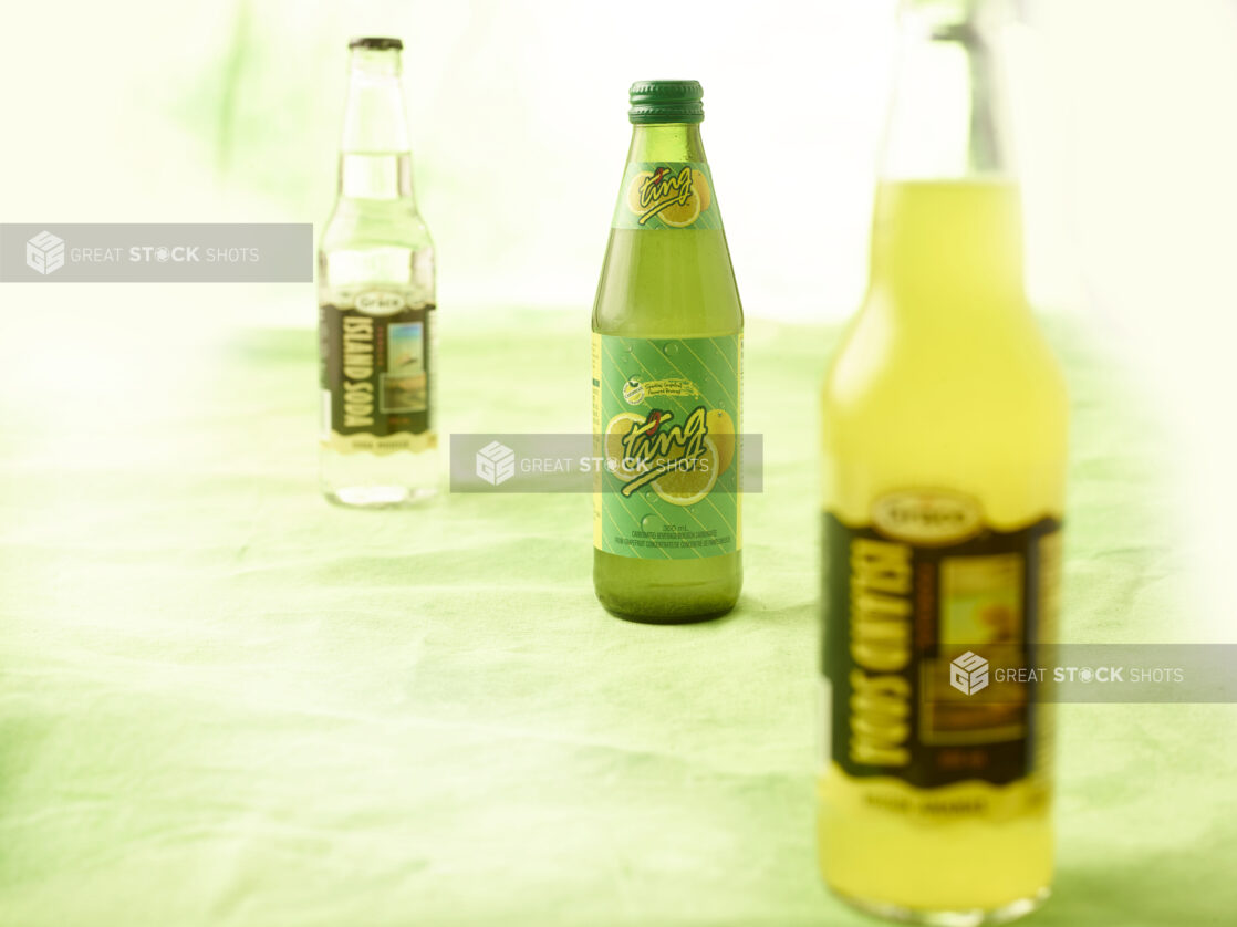 3 Caribbean sodas in glass bottles on lemon/lime green tablecloth