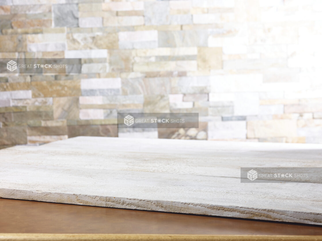 Rustic white wooden planks on a table with a limestone wall in the background