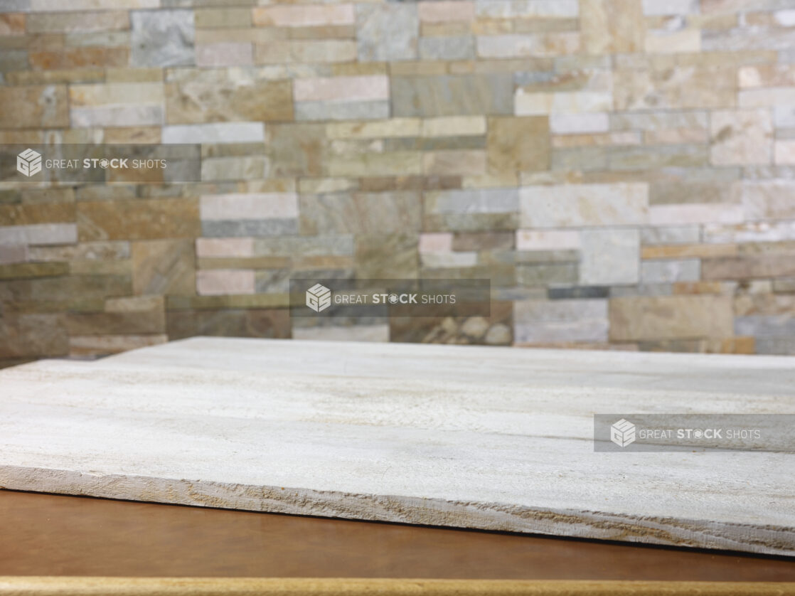 Rustic white wooden planks on a table with a limestone wall in the background