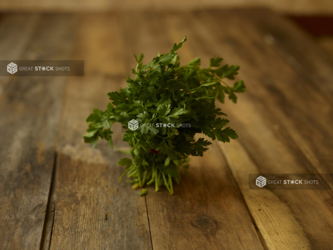 Bunch of Parsley on a rustic wooden table, straight on view