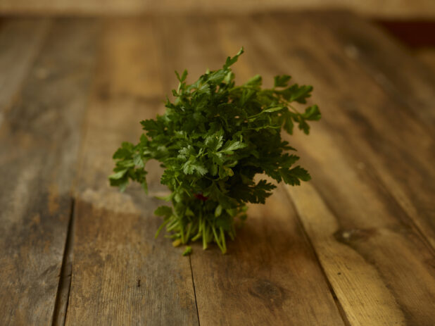 Bunch of Parsley on a rustic wooden table, straight on view